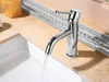A chrome faucet in a bathroom, with water running into a sink. Podgląd zdjęcia produktu