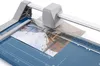 A close-up shot of a paper cutter with a photograph being cut. Voir les images du produit