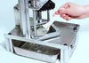 A hand is using a brush to clean a vertical potato chip slicer machine. Náhled obrázku produktu