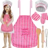 A young girl wearing a pink gingham chef's outfit, including a hat and apron, holding a toy rolling pin and oven mitt. Náhled obrázku produktu