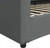 A close-up view of the corner of a dark gray fabric bed frame, showing the wooden slats of the bed base. Náhled obrázku produktu