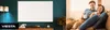 A split image showing a wall heater on the left and a couple relaxing on a couch on the right. Voir les images du produit