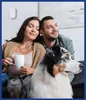 A couple and their dog relaxing on a couch, with a carbon monoxide detector mounted on the wall. Náhled obrázku produktu