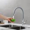A hand is washing a green fruit under a gray flexible kitchen faucet. Produktbild-Vorschau