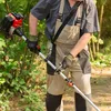A person is using a gas-powered string trimmer in a wooded area. Produktbild-Vorschau