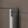 A close-up view of a shower enclosure corner, showing the metal frame and glass panel. Voir les images du produit