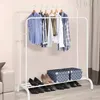 A white metal garment rack with clothes hanging on it and shoes and boxes on the bottom shelf. Podgląd zdjęcia produktu