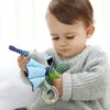 A baby is holding a toy. Produktbild-Vorschau