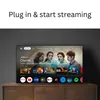 A smart TV displaying a streaming interface with various app icons and movie posters, placed on a wooden cabinet. Produktbild-Vorschau