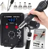 A hand holding a hot air soldering gun over a control unit, with various nozzles and a booklet in the foreground. Produktbild-Vorschau