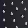 A collection of small, white, cone-shaped objects scattered on a black background. Anteprima dell’immagine prodotto