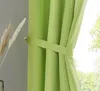 A close-up of a green curtain tied back with a fabric tie. Produktbild-Vorschau