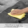 A hand is wiping a gray fabric with a yellow cloth, showing water droplets on the fabric. Náhled obrázku produktu