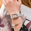 A close-up shot of a woman's wrist wearing a silver watch and a bracelet. Produktbild-Vorschau