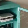 Close-up of a teal metal cabinet with books on a shelf and a glass door slightly open. Produktbild-Vorschau
