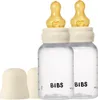 Two baby bottles with yellow nipples and ivory caps are shown against a white background. Produktbild-Vorschau