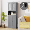 A gray bathroom cabinet is shown in a room next to a sofa and a plant. A close-up of an anti-tip device is also shown. Náhľad obrázku produktu