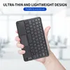 A hand holding a black ultra-thin keyboard with a touchpad. Náhled obrázku produktu