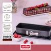 A baking pan with raspberries and a cake in the background. Produktbild-Vorschau