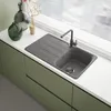 A modern kitchen sink with a gray faucet and a gray sink basin, set against a white countertop and green cabinets. Podgląd zdjęcia produktu