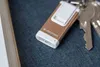 A small gold flashlight with a white clip is attached to a set of keys, resting on a dark textured surface. Anteprima dell’immagine prodotto