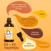 A product shot of a bottle of vitamin drops with accompanying marketing text bubbles. Produktbild-Vorschau