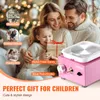 A family is gathered around a pink pottery wheel, with a gift box in the foreground. The background is festive with Christmas lights. Produktbild-Vorschau