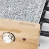 A close-up view of a raclette grill, focusing on the wooden base with controls and the granite cooking surface. Produktbild-Vorschau