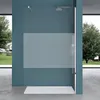 A modern walk-in shower enclosure with a frosted glass panel, set against a teal wall and a concrete floor. Large windows with a view of a garden are visible on either side. Produktbild-Vorschau