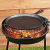 A cast iron crepe pan is placed on a grill over hot coals. Voir les images du produit
