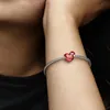 A close-up shot of a person's arm wearing a Pandora bracelet with a red heart-shaped charm. Produktbild-Vorschau