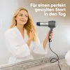 A woman in a bathrobe is drying her hair in front of a mirror with a hairdryer. Anteprima dell’immagine prodotto