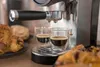 Eine Nahaufnahme der Unold Espressomaschine Piccopresso, die zwei Shots in Glastassen brüht, mit Tel Produktbild-Vorschau