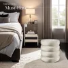 A bedroom scene with a bed, nightstand, lamp, and ottoman. Náhled obrázku produktu