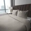 A neatly made bed with beige striped satin bedding and two pillows, placed in a room with a large window and a headboard. Anteprima dell’immagine prodotto