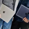 Two people holding MacBooks. Produktbild-Vorschau