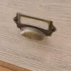 A close-up shot of a vintage-style drawer pull on a wooden surface. Voir les images du produit