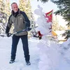 A man is shoveling snow in a snowy outdoor environment with trees in the background. Náhled obrázku produktu