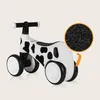 A children's ride-on toy with a cow pattern against a plain background. Anteprima dell’immagine prodotto