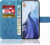 A blue flip case for a Xiaomi Mi 11 5G phone, shown open with cards and euro banknotes inserted. Produktbild-Vorschau