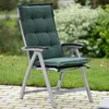 A dark green garden chair cushion on a folding chair, placed on a paved patio with grass and bushes in the background. Produktbild-Vorschau