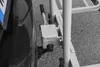 A close-up view of a quick-release mechanism attached to a vehicle's tire and a trailer hitch. Podgląd zdjęcia produktu