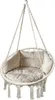 A white macrame hanging chair with cream cushions, suspended by ropes against a white background. Náhled obrázku produktu