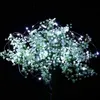 A bouquet of small white flowers intertwined with a string of micro LED lights. Voir les images du produit