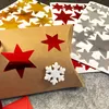 A close-up view of a brown pillow box decorated with red star stickers and a white snowflake. Produktbild-Vorschau