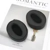 Two black ear pads are placed on a white surface with text. Anteprima dell’immagine prodotto