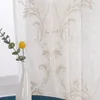 A close-up of a sheer curtain with a damask pattern, next to a vase with a single yellow flower. Produktbild-Vorschau