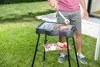 A person is grilling food on an electric grill in a backyard. Náhled obrázku produktu