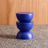 A blue stool or side table is shown against a wooden background and a speckled surface. Anteprima dell’immagine prodotto