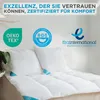 A close-up view of white pillows and a comforter on a bed, with certification logos and text overlays. Produktbild-Vorschau